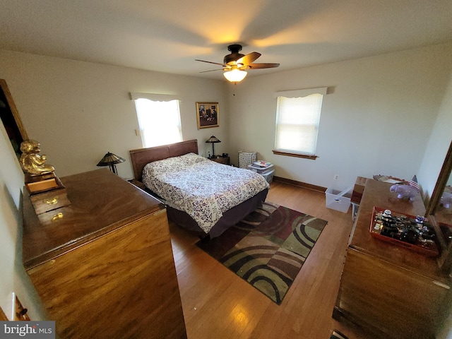 bedroom with wood finished floors, a ceiling fan, and baseboards