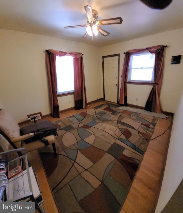 bedroom featuring multiple windows, a ceiling fan, and baseboards