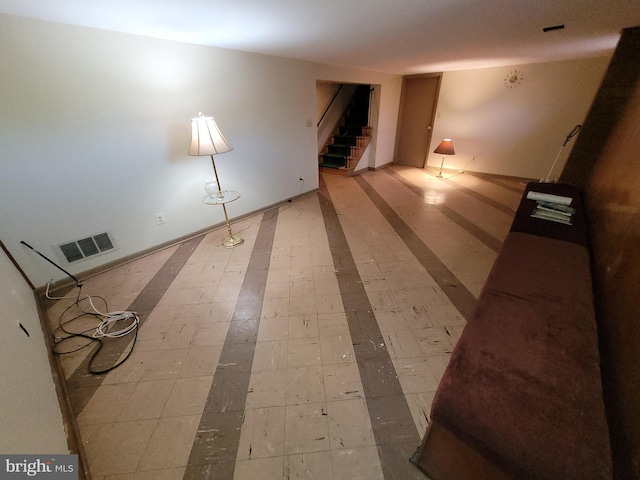 unfurnished living room featuring stairs