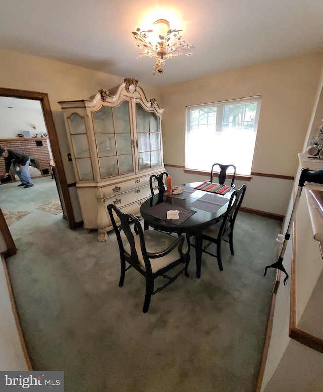 dining room featuring light colored carpet and baseboards