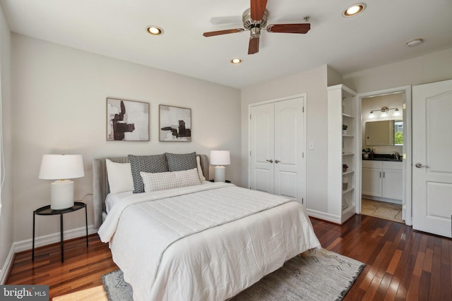 bedroom with a closet, recessed lighting, wood-type flooring, and baseboards
