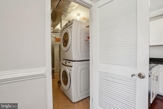 laundry area with laundry area, light tile patterned floors, and stacked washer / drying machine