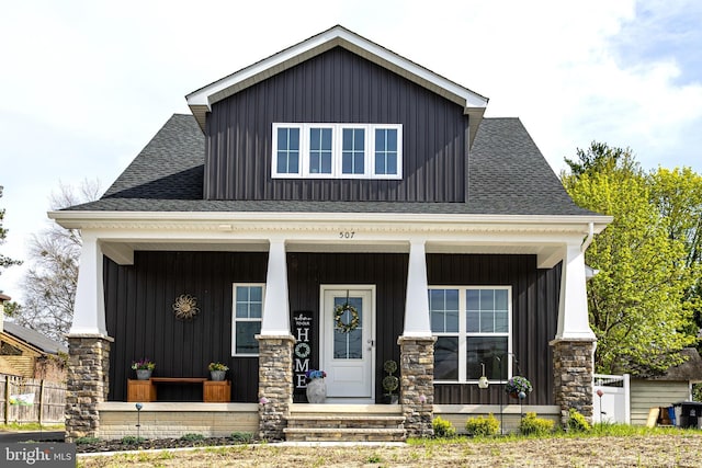 view of front facade with a porch, a shingled roof, and board and batten siding