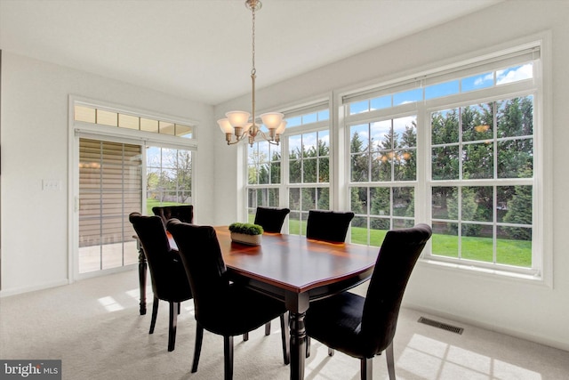 dining room with a notable chandelier, visible vents, a wealth of natural light, and carpet