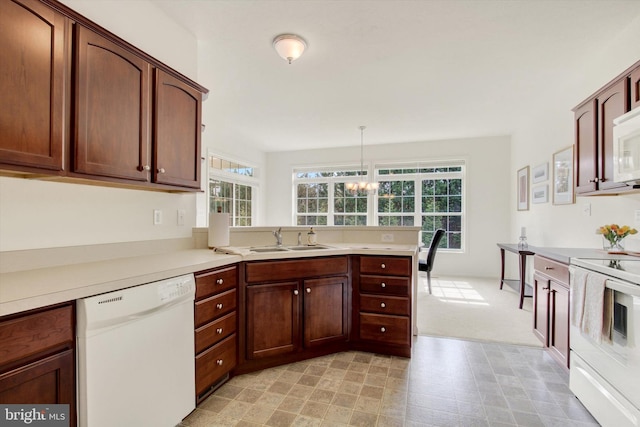 kitchen with a sink, a peninsula, a wealth of natural light, and white appliances
