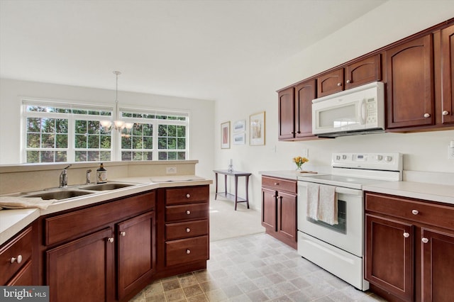 kitchen featuring light carpet, white appliances, light countertops, a chandelier, and a sink