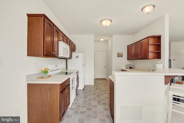 kitchen with open shelves, white appliances, a kitchen breakfast bar, light countertops, and a peninsula