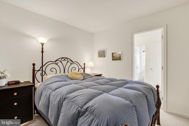 bedroom featuring ensuite bathroom and light carpet