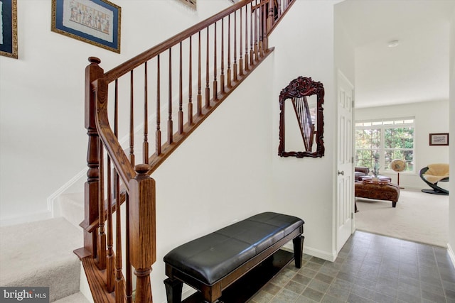 stairway featuring carpet flooring and baseboards