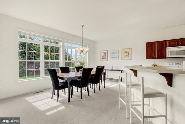 dining room with baseboards, visible vents, a chandelier, and light colored carpet