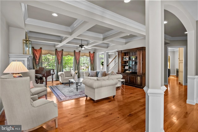 living room with ceiling fan, beam ceiling, arched walkways, light wood-type flooring, and coffered ceiling