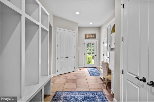 mudroom with baseboards, recessed lighting, and light tile patterned flooring