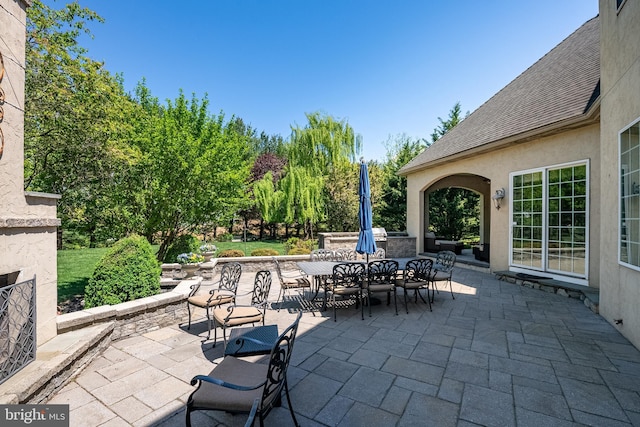 view of patio / terrace with an outdoor stone fireplace and outdoor dining area