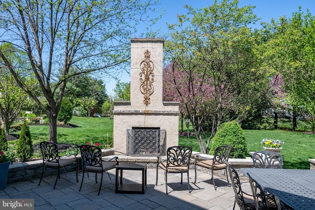 view of patio featuring an outdoor stone fireplace and outdoor dining space