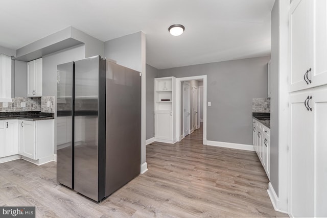 403 E Fourth St, Waynesboro, PA 17268 - kitchen featuring light wood-type flooring, freestanding refrigerator, decorative backsplash, and white cabinets