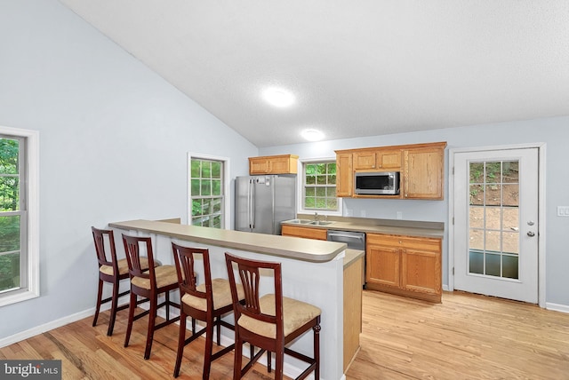 806 Windy Way, Front Royal, VA 22630 - kitchen with appliances with stainless steel finishes, a kitchen bar, light wood-type flooring, vaulted ceiling, and plenty of natural light