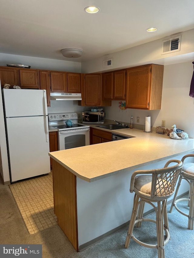 12304 Jamaica Ave Unit 206, Ocean City, MD 21842 - kitchen with visible vents, light countertops, a peninsula, under cabinet range hood, and white appliances
