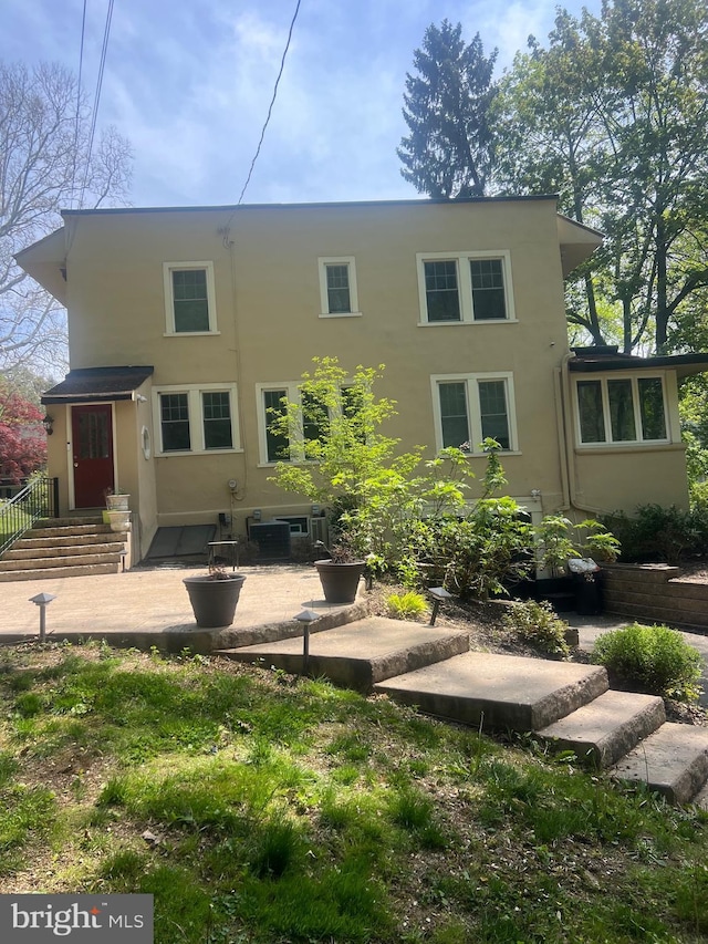 back of property with stucco siding and a patio area