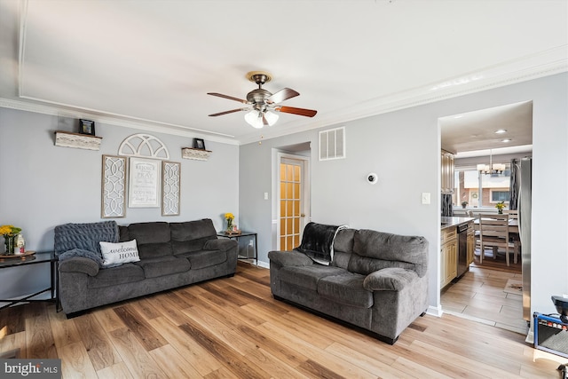 living room featuring visible vents, ornamental molding, light wood-style floors, and ceiling fan with notable chandelier