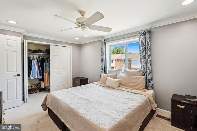 bedroom with a closet, recessed lighting, ornamental molding, and light colored carpet