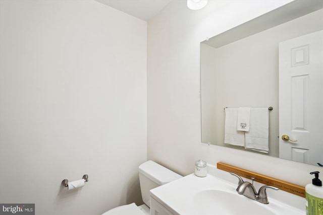 half bathroom with vanity and toilet