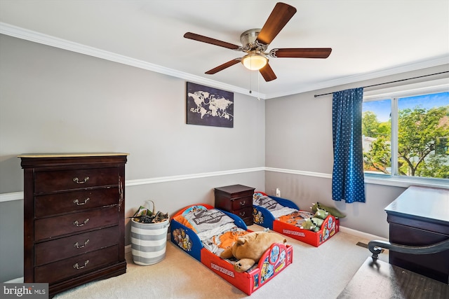 carpeted bedroom with crown molding, a ceiling fan, and baseboards