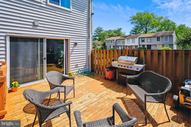 view of patio featuring a wooden deck, grilling area, and a residential view