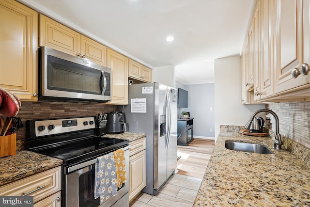 kitchen featuring a sink, stainless steel appliances, cream cabinetry, tasteful backsplash, and ornamental molding