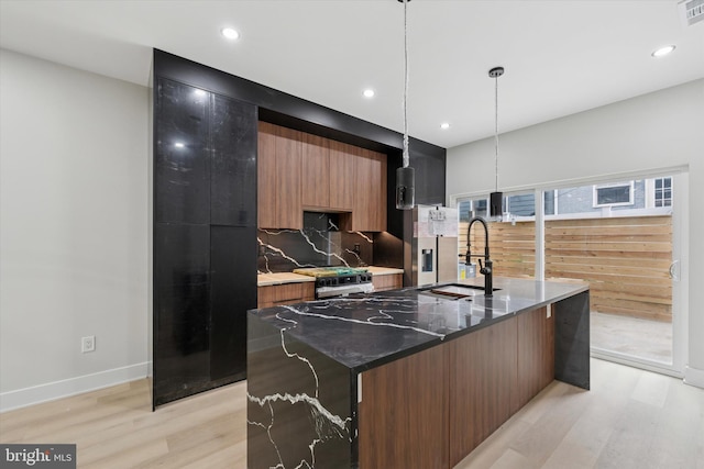 2230 Kimball St, Philadelphia, PA 19146 - kitchen featuring a sink, modern cabinets, light wood-style floors, tasteful backsplash, and an island with sink