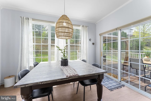 dining space featuring crown molding, a notable chandelier, and wood finished floors