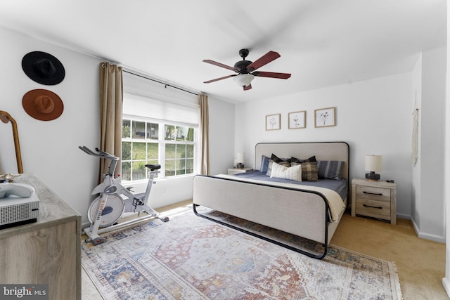bedroom with a ceiling fan, baseboards, and light colored carpet