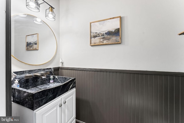 bathroom with a wainscoted wall and vanity