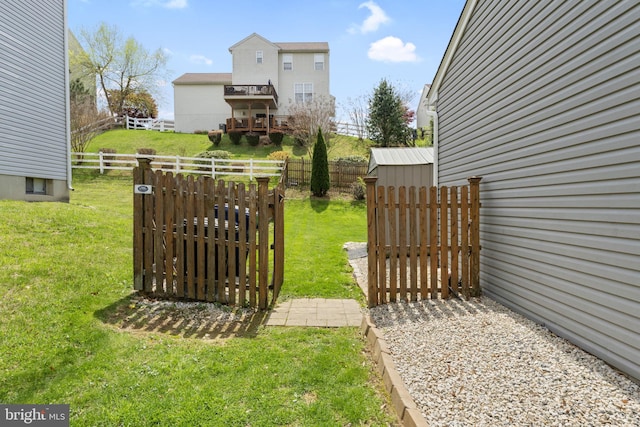 view of yard featuring fence, an outbuilding, and a gate