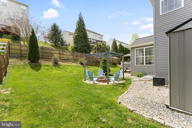 view of yard featuring a fenced backyard, a fire pit, a patio area, and a pergola