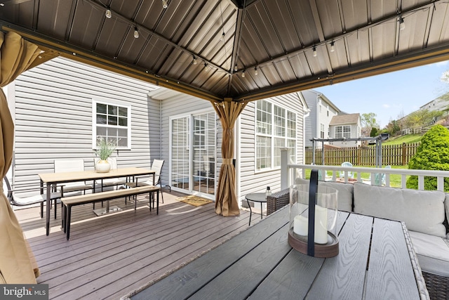 wooden terrace featuring fence, an outdoor hangout area, and outdoor dining area