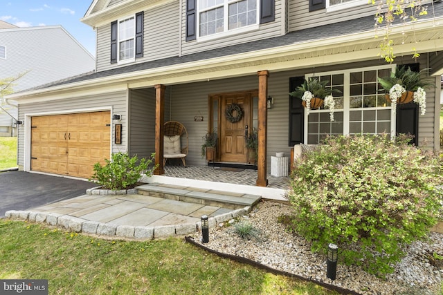 entrance to property with covered porch and aphalt driveway