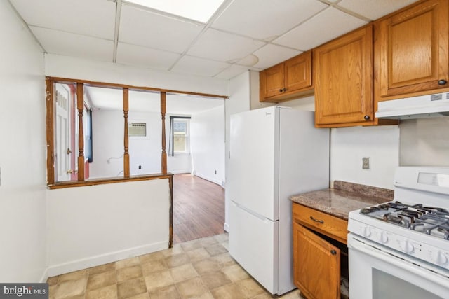 8 Sullivan Ave, Bellmawr, NJ 08031 - kitchen featuring white appliances, under cabinet range hood, a paneled ceiling, brown cabinets, and an AC wall unit