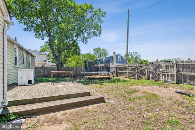 8 Sullivan Ave, Bellmawr, NJ 08031 - fenced backyard featuring a wooden deck and a trampoline
