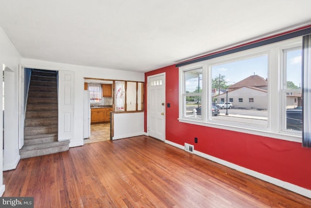 8 Sullivan Ave, Bellmawr, NJ 08031 - unfurnished living room featuring baseboards, wood finished floors, and stairs