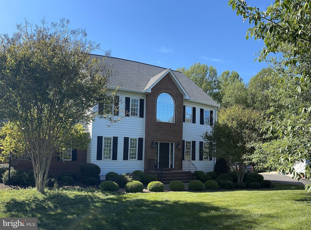 colonial house with brick siding and a front lawn
