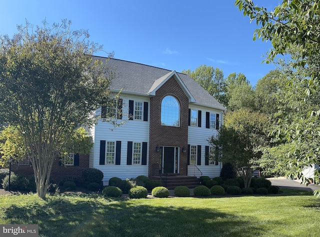 colonial house with brick siding and a front lawn