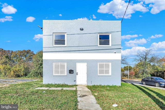 view of front of property with a front yard and brick siding