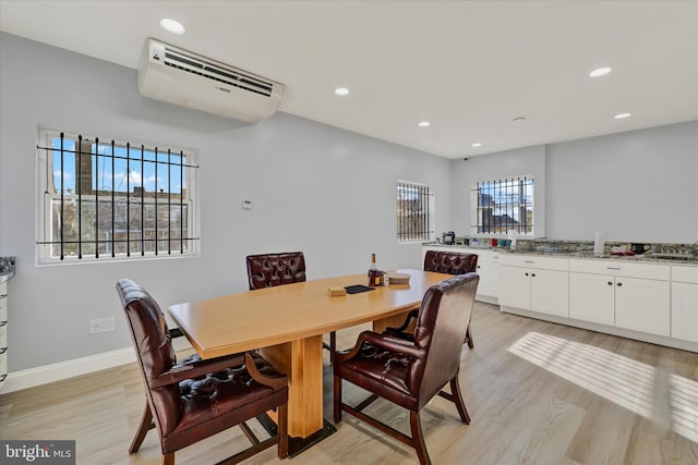 dining room with light wood-type flooring, a wall mounted air conditioner, and recessed lighting
