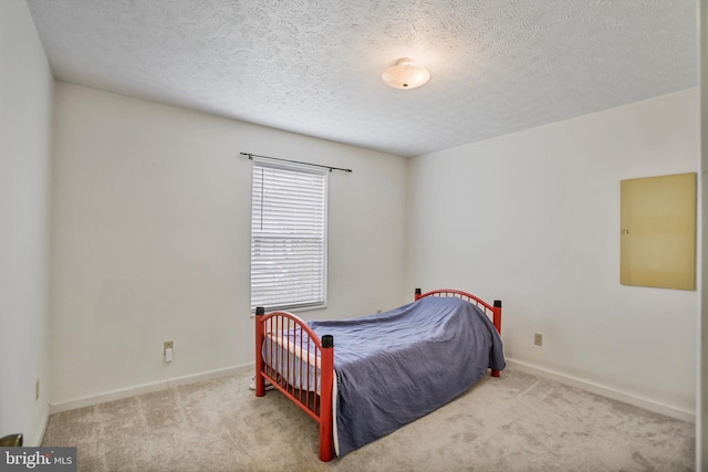 carpeted bedroom featuring a textured ceiling and baseboards