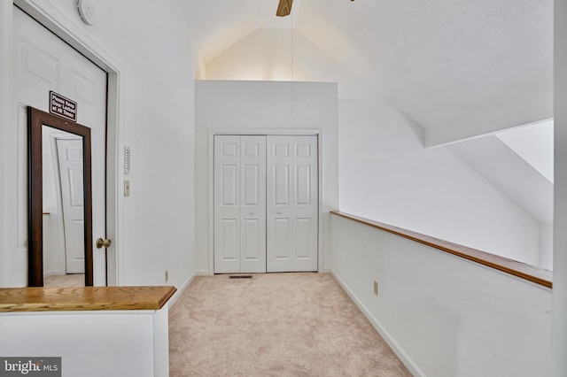 interior space featuring carpet floors, baseboards, and lofted ceiling