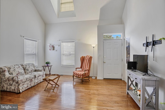 living area featuring light wood-style floors and high vaulted ceiling