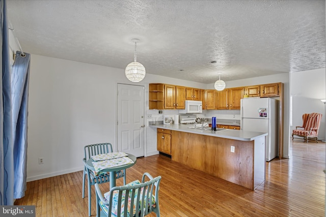 kitchen with open shelves, a peninsula, white appliances, baseboards, and a textured ceiling