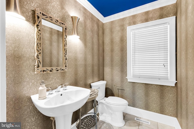 half bathroom with baseboards, wallpapered walls, toilet, and visible vents
