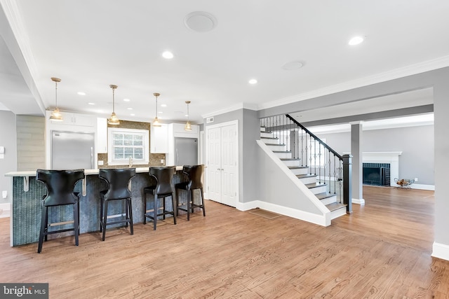 kitchen with crown molding, white cabinetry, built in refrigerator, and baseboards