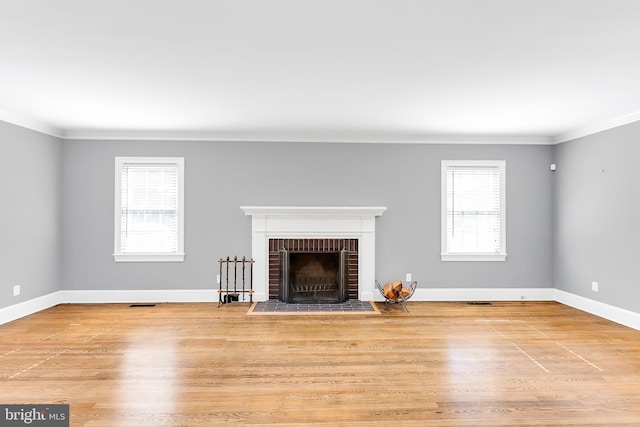 unfurnished living room featuring crown molding, light wood-style floors, and a fireplace